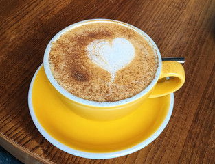  yellow cappuccino cup on the table