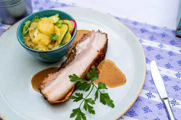 Bayerischer Schweinebraten vom Schweine Bauch und Kartoffelsalat mit Gurken  und Sauce oktoberfest