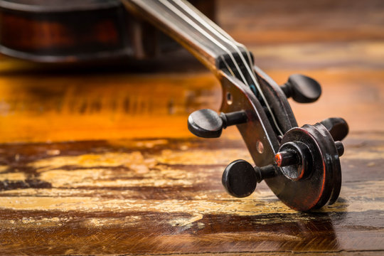 Old violin in vintage style on wood background