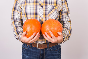 Agriculture, autumn, people concept - Close up of man farmer with two pumpkins on white background.