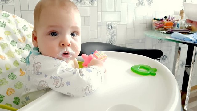 Mom feeds the baby with a spoonful of mush