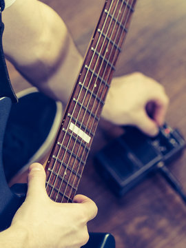 Man adjusting guitar effects pedal
