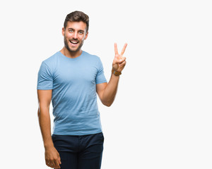 Naklejka premium Young handsome man over isolated background smiling with happy face winking at the camera doing victory sign. Number two.