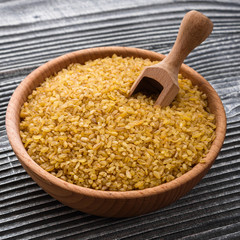 raw bulgur on a rustic wooden background
