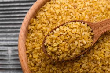 raw bulgur on a rustic wooden background