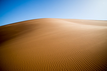 Fototapeta na wymiar Sand dunes and waves in the sand.