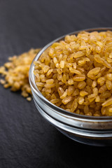 raw bulgur on a dark stone background