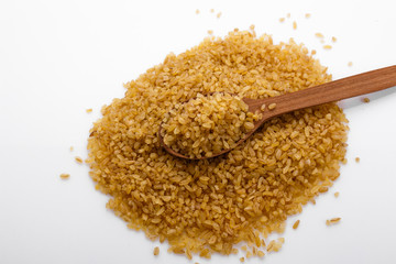 raw bulgur on a white acrylic background
