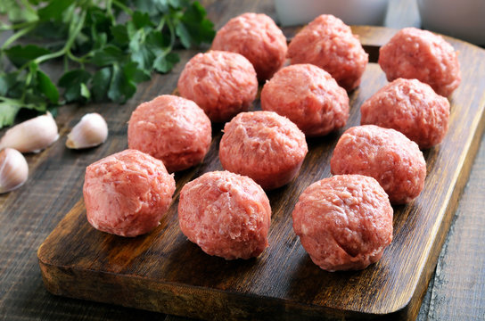 Raw meatballs on a cutting board
