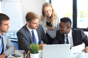Startup business team on meeting in modern bright office interior and working on laptop.