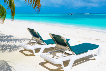 Fototapeta na wymiar Lounge chair on the white sandy beach