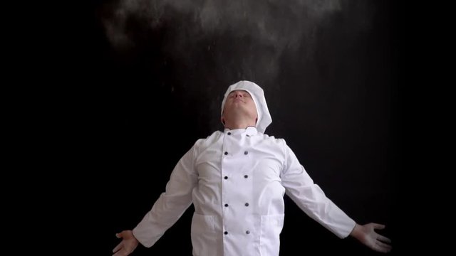 adult chef in white suit and cap on dark background