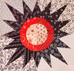 A colorful quilt pattern sewn in a star burst