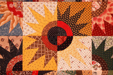 A colorful quilt pattern sewn in a star burst 