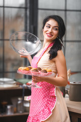 Young attractive woman on kitchen. Girl baking muffins