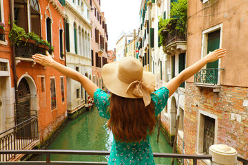 Naklejka premium Europa podróży wakacje zabawy lato kobieta z rękami up i kapelusz szczęśliwy w Wenecja, Włochy. Beztroski turysta dziewczyna w europejskim miejscu na sobie zieloną sukienkę mody .. \ t