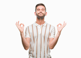 Fototapeta premium Young handsome man over isolated background relax and smiling with eyes closed doing meditation gesture with fingers. Yoga concept.