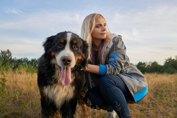Beautiful girl with a dog portrait on the nature