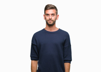 Obraz premium Young handsome man wearing winter sweater over isolated background with serious expression on face. Simple and natural looking at the camera.