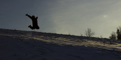 silhouette of man jumping on the background of blue sky