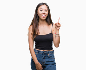 Young asian woman over isolated background pointing finger up with successful idea. Exited and happy. Number one.