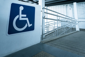 Concret ramp way with stainless steel handrail with disabled sign for support wheelchair disabled people. - obrazy, fototapety, plakaty