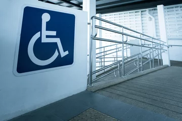 Fotobehang Concret ramp way with stainless steel handrail with disabled sign for support wheelchair disabled people. © Bill45