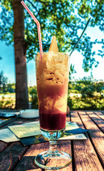 tall glass of frappe, cold sweet drink on summer day