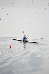 Fototapeta na wymiar Young kayaker studying to float on kayak on the lake