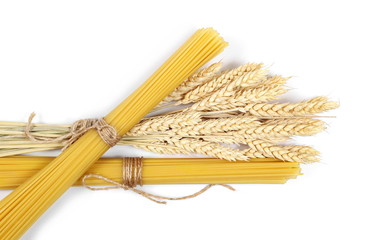 Dry wheat ears, grain with raw pasta noodles for spaghetti isolated on white background, top view