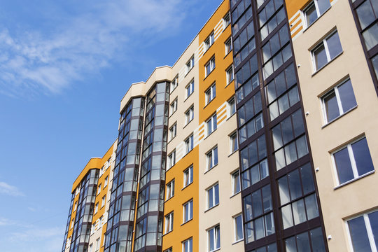 Modern apartment building in sunny day against blue sky.