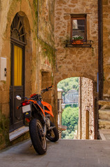 Fototapeta na wymiar Motorbike on the old street of Pitigliano, Italy