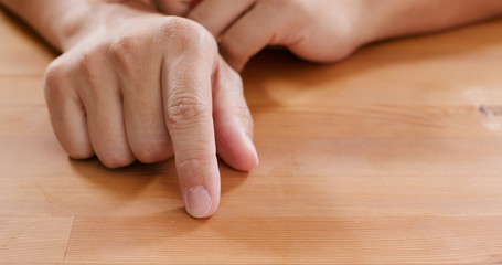 Adult man hand finger tapping on table
