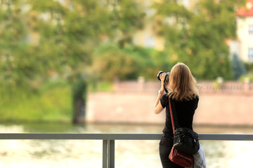 Fotograf, piękna dziewczyna robi zdjęcia krajobrazu nad rzeką Odrą we Wrocławiu.