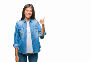 Young asian woman over isolated background doing happy thumbs up gesture with hand. Approving expression looking at the camera with showing success.