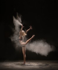 Obraz na płótnie Canvas Slim dancer being enveloped in white powder cloud