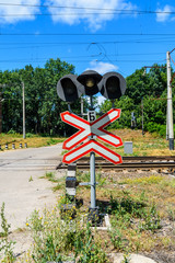 Railroad crossing sign and semaphore in front of the railroad crossing