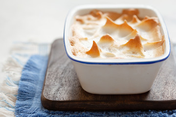 Homemade apple meringue pie in baking dish copy space