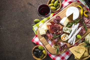 Antipasto - sliced meat, ham, salami, cheese, olives on wooden b