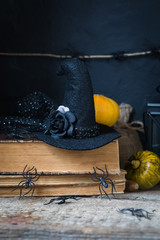 Halloween holiday background with spiders, old books, black witchhat
