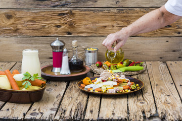 Manos de persona preparando patatas aliñadas.