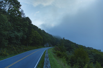 A windy road fades off into the distance in Shenandoah National Park, VA as it's engulfed by clouds.