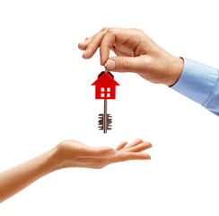 Man's hand giving the house key to woman's hand isolated on white background. Close up. High...