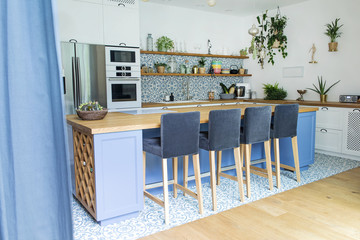 Fresh summer breakfast in Mediterranean style kitchen. Bright and sunny space with a lot of herbs and plants.