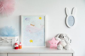 Stylish scandinavian nursery interior with mock up photo frame , mirror, pinky star and toys. The...