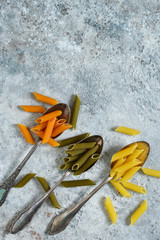 Obraz premium Variety of pasta on a concrete background. Raw paste for cooking. Italian pasta.