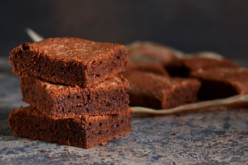 Brownie is a classic American dessert. Pie with chocolate sauce on a dark background.