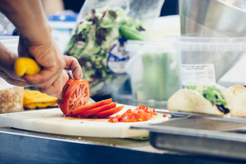 Chef hands cutting tomato