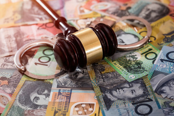 Judge's gavel with handcuffs on australian dollars