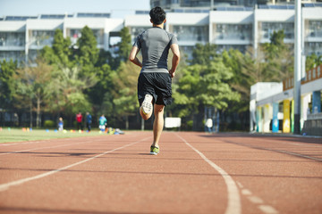 Fototapeta na wymiar young asian male athlete running on track